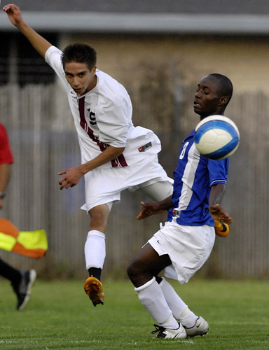 GHS_AHS_DSC0192b Alan Portilla (left) of Glenoe sends a cross in past Aloha defender Abraham Korpah (right) that found Zim Mayfield just outside the six yard box who put it in the back of the net for the lead goal in Glencoe's 2-1 victory over the visiting Warriors.