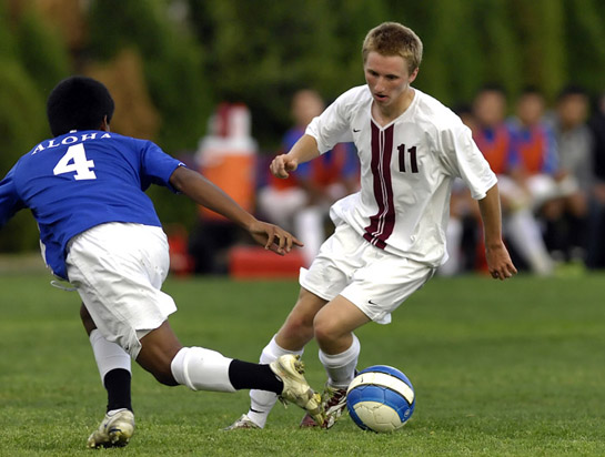 GHS_AHS_DSC9937b Zim Mayfield (11) of Glencoe dodges around the defense of Aloha's Erick Flores (4) as he heads into the penalty box during a second half attack.