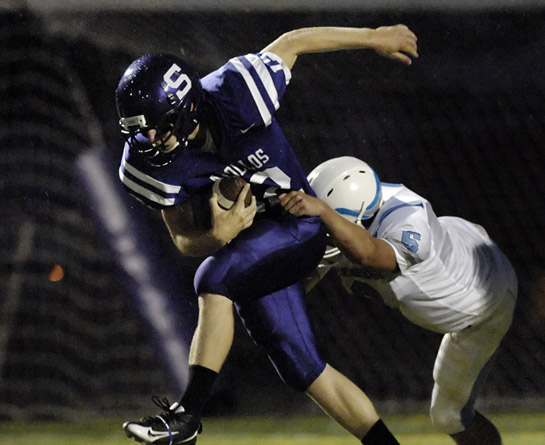 SHS_LHS_DSC8687b Ty Harper (12) of Sunset runs for a twelve yard first down late in the first quarter before being brought down by Lakeridge's James Adler (6).