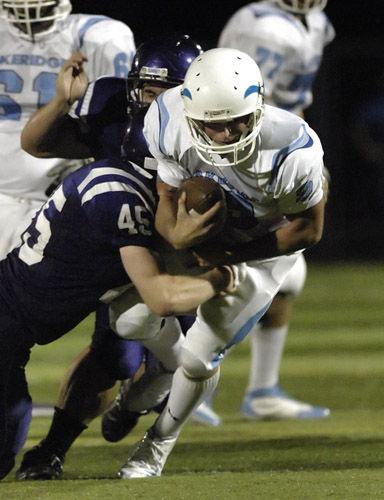 SHS_LHS_DSC9083b Lakeridge quarterback Ben Swinford rushes for five yard to gain a first down before being stopped by Sunset's Sam Novak (45) late in the third quarter.
