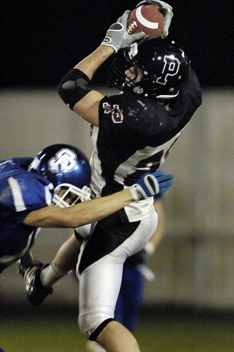 SPHS_PHS_DSC9006b Blake Barnes of Perrydale earns four yards the hard way as he is hit hard by St. Paul’s Ryan Pierson as he leaps high to pull down a pass reception.