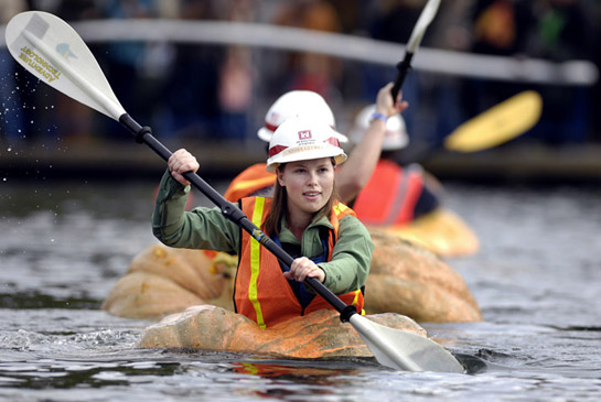 GPR09_DSC7720b Nisha Georga of the U.S. Army Corps of Engineers paddles her way across the Lake at the Commons in Tualatin, Oregon as she and other corps members particpate in a challenge race against city of Tualatin employees.