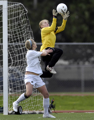 BHS_SHS_DSC5983b Sherwood goalkeeper Kassee Flint goes high to pull in a cross to foil a goal-scoring opportunity for Bend's Kelsey Corney.
