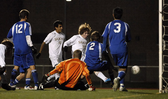 SSHS_SMHS_DSC4197b Ethan Jones (center in white) sticks away a rebound off a save by South Medford keeper Mitch North (in orange) to score the game winning goal for the Saxons with 13:45 left in the match.