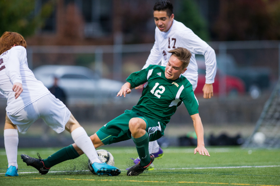 Rex Putnam midfielder Chris Taylor (12) slides for a tackle against Evan McClelland (12) of Milwaukie.