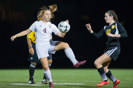 Milwaukie midfielder Ellie Holmes (4) battles for a loose ball under pressure from Rex Putnam midfielder Abigail Herbert (10).