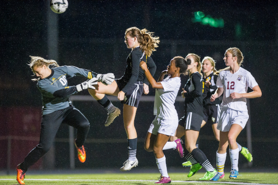 Rex Putnam midfielder Megan Spaulding (11) plays the ball over the reach of the on-rushing Milwaukie goalkeeper Celeste Levasseur (00) with the ball settling into the goal, however the play was called back due to a Rex Putnam foul.